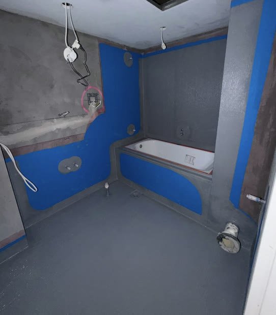 Bathroom with bath surround waterproofed in blue membrane
