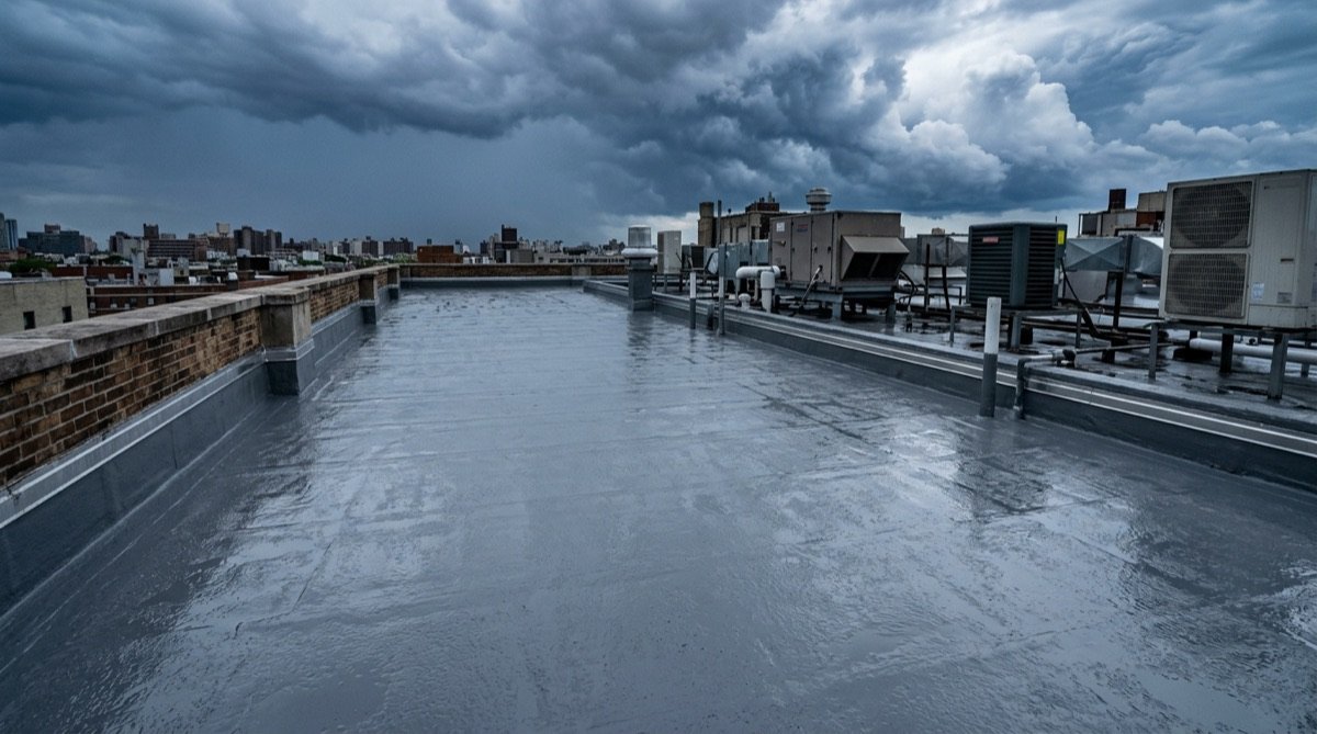 Flat commercial roof coated in grey waterproof membrane